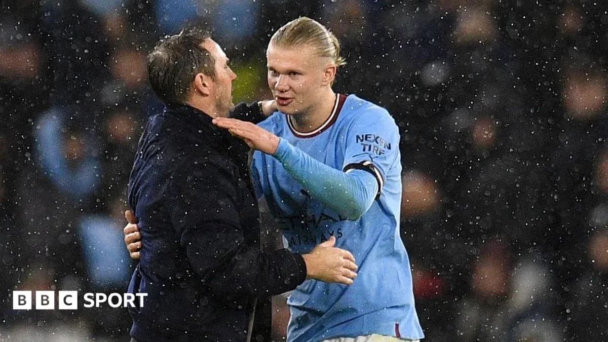 Player and coach discussing on rainy pitch