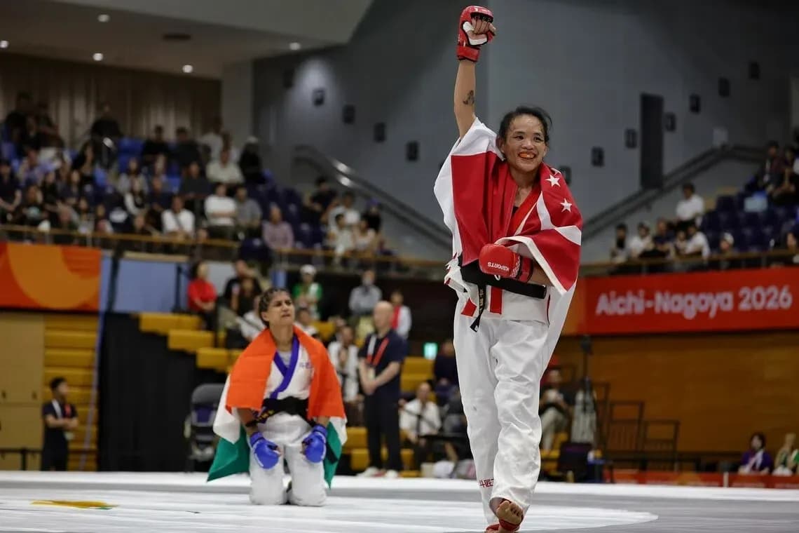 Winning martial artist celebrating with raised arm