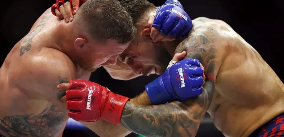 Two fighters clinching in a boxing match