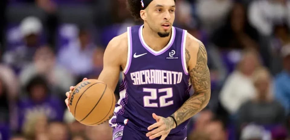 Player dribbling basketball in Sacramento Kings uniform
