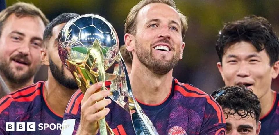 Player celebrating with trophy and teammates