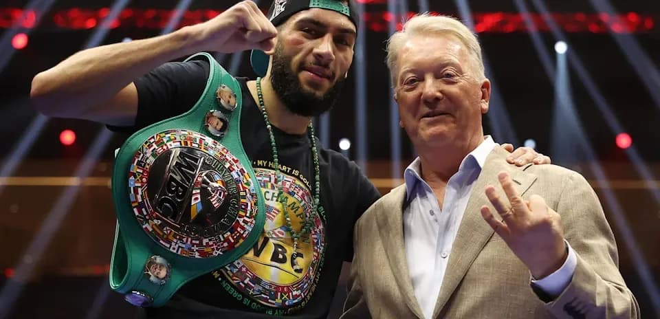 Boxer with championship belt alongside promoter Frank Warren