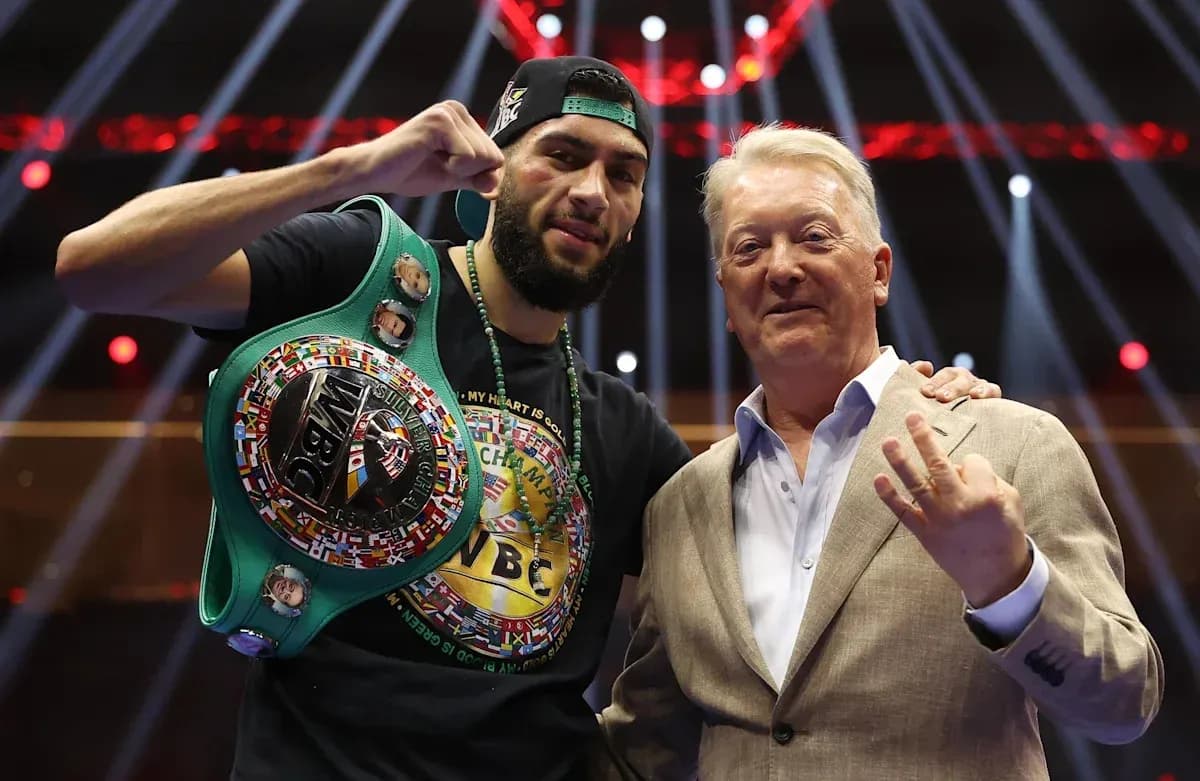 Boxer with championship belt alongside promoter Frank Warren