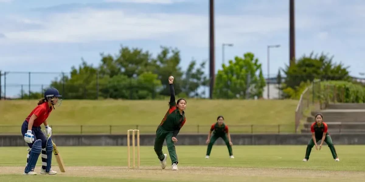 Bowler delivering ball with fielders positioned nearby