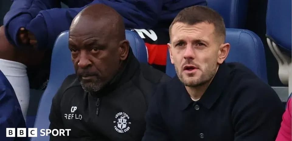 Two individuals seated on the sidelines during match
