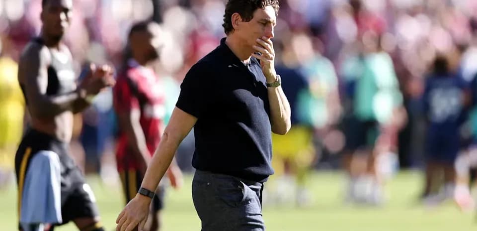 Coach walking on pitch after match conclusion