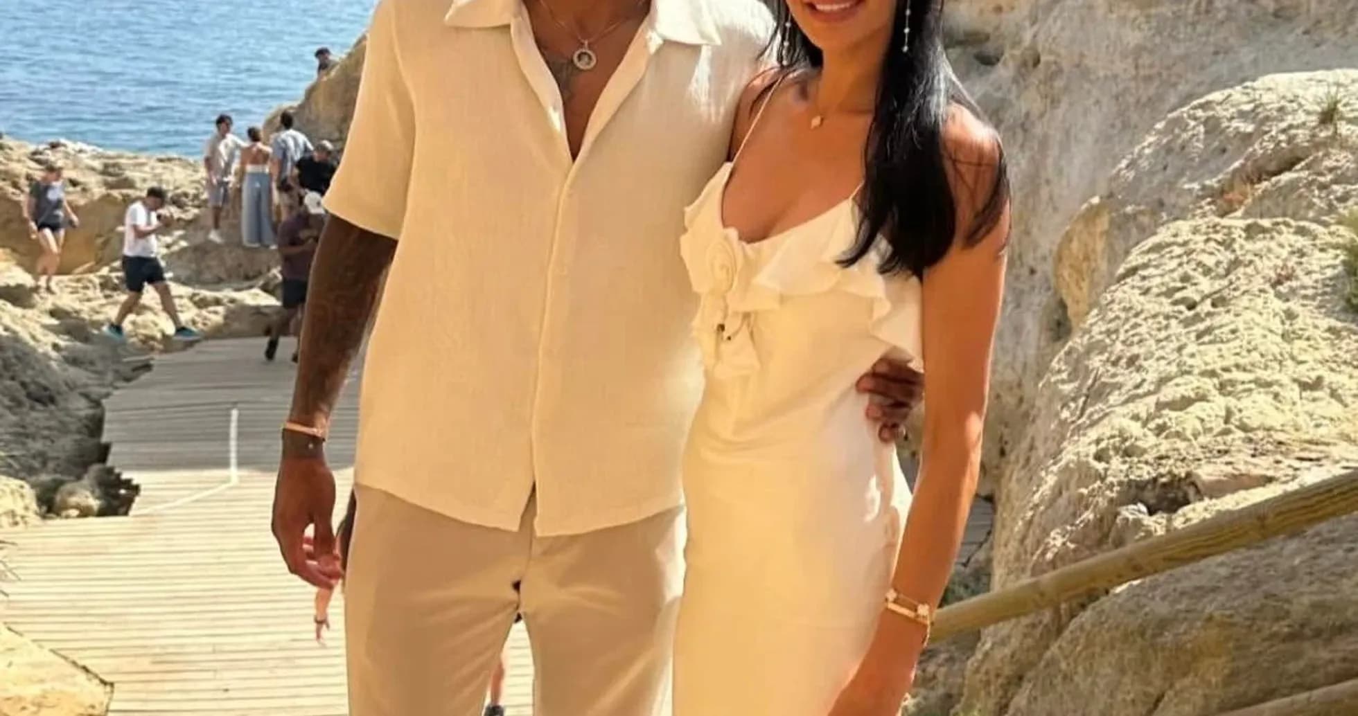 Couple posing together near rocky coastline