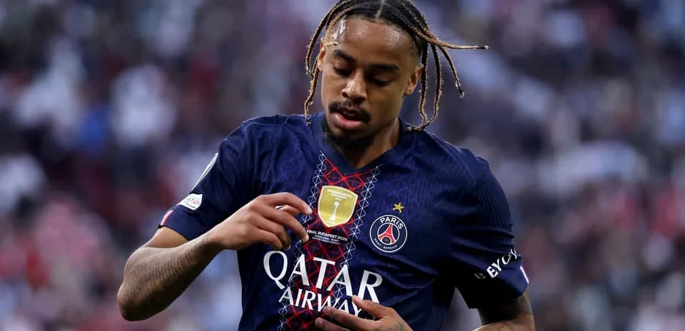 Player inspecting badge on PSG jersey during match
