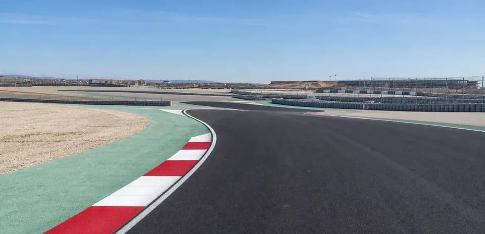 Curved racetrack with safety barriers and clear sky