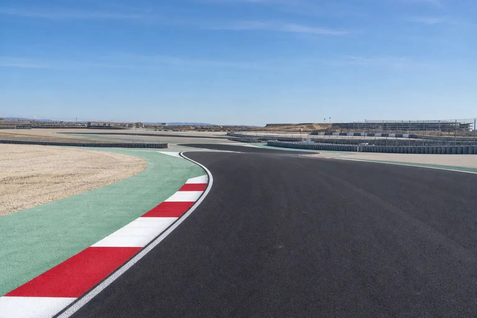 Curved racetrack with safety barriers and clear sky