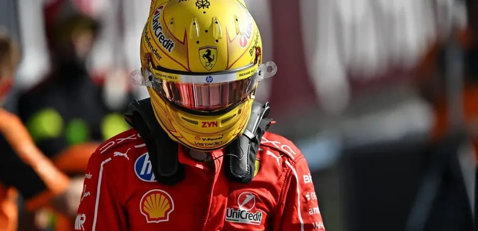 Driver wearing helmet and racing suit in paddock