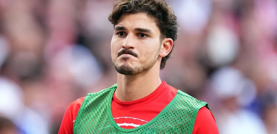 Player in training vest on sidelines during match