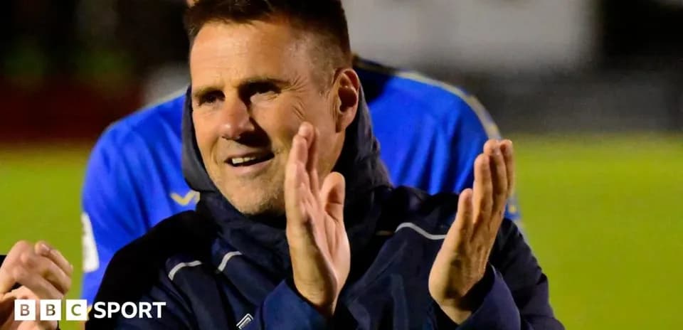 Coach applauding during a post-match celebration