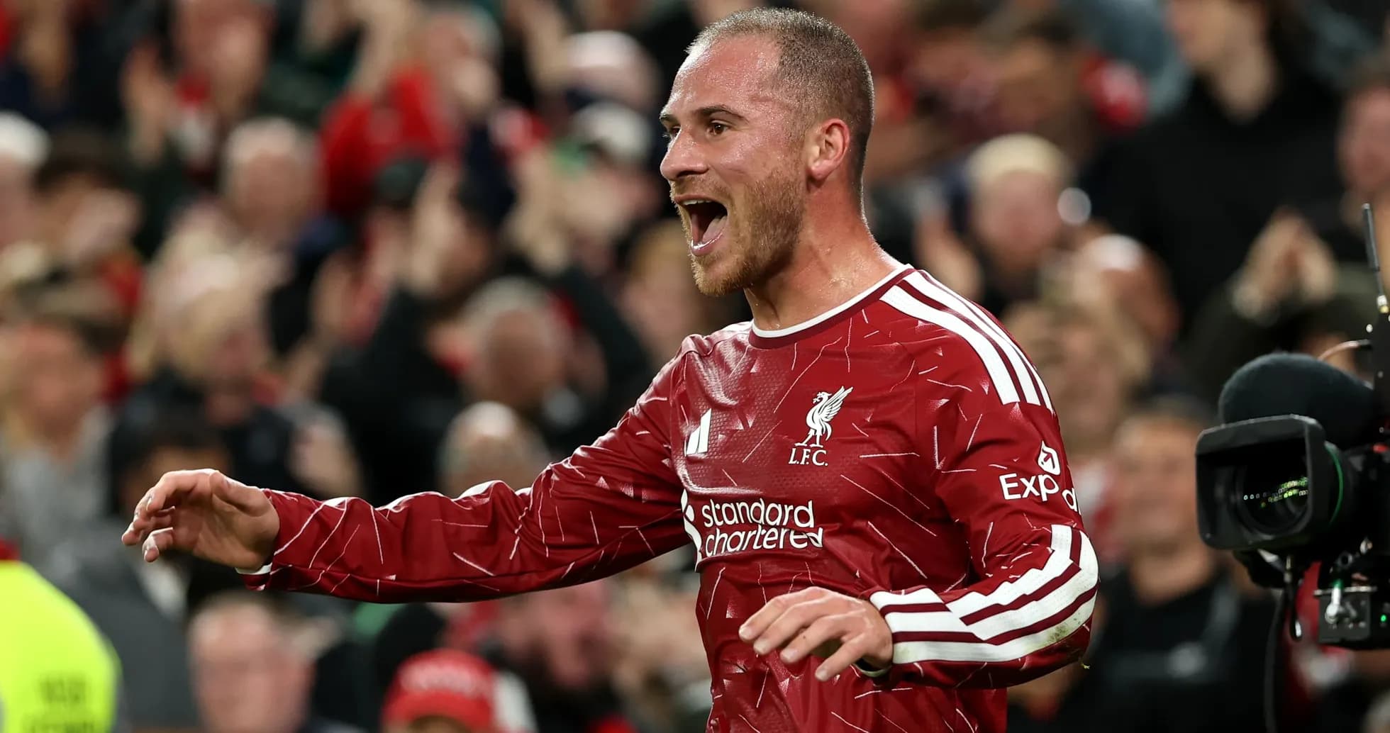 Player celebrating in Liverpool kit with fans cheering