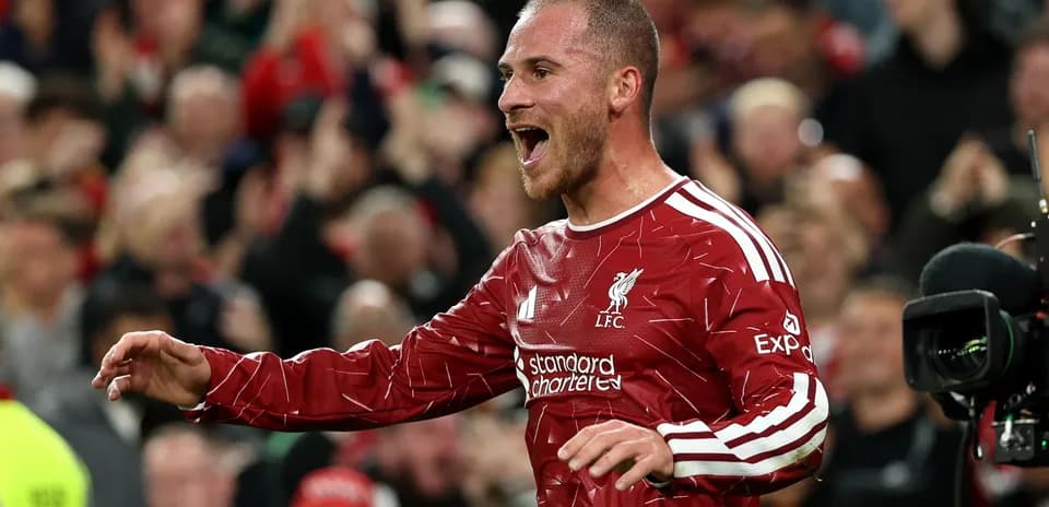 Player celebrating in Liverpool kit with fans cheering