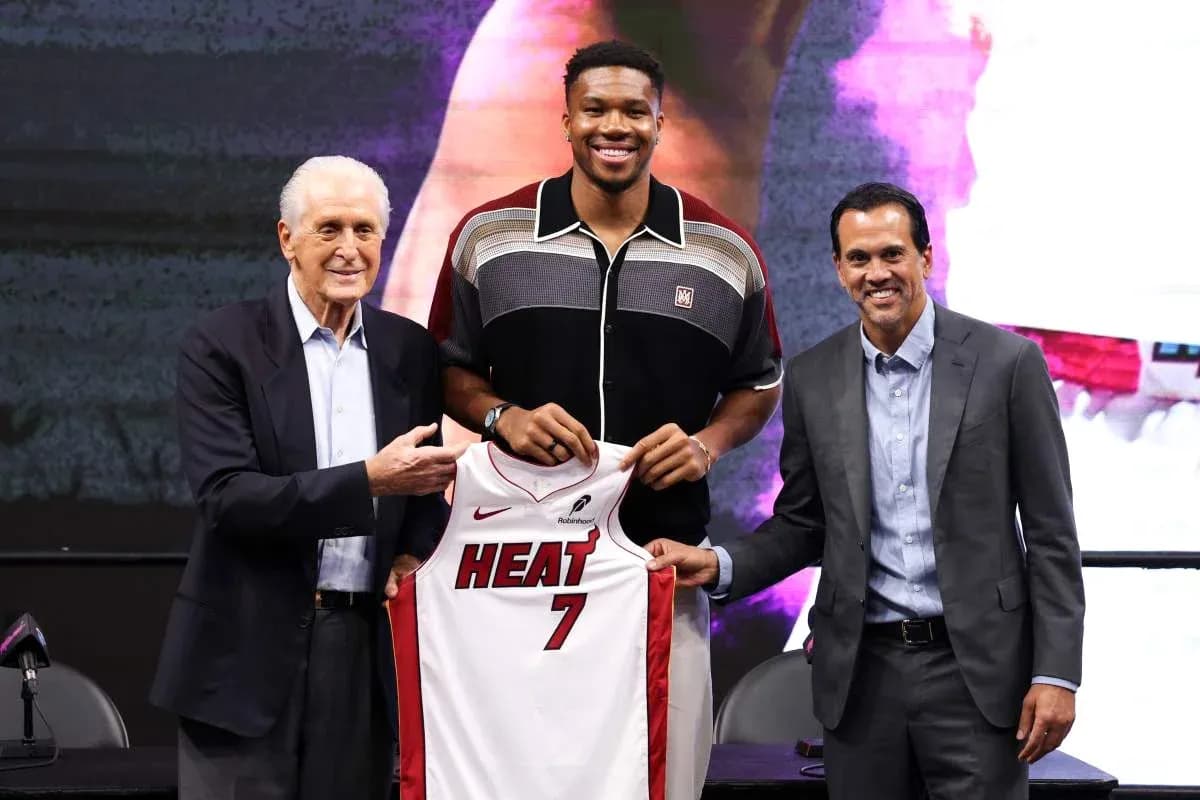 New player holding Miami Heat jersey with executives