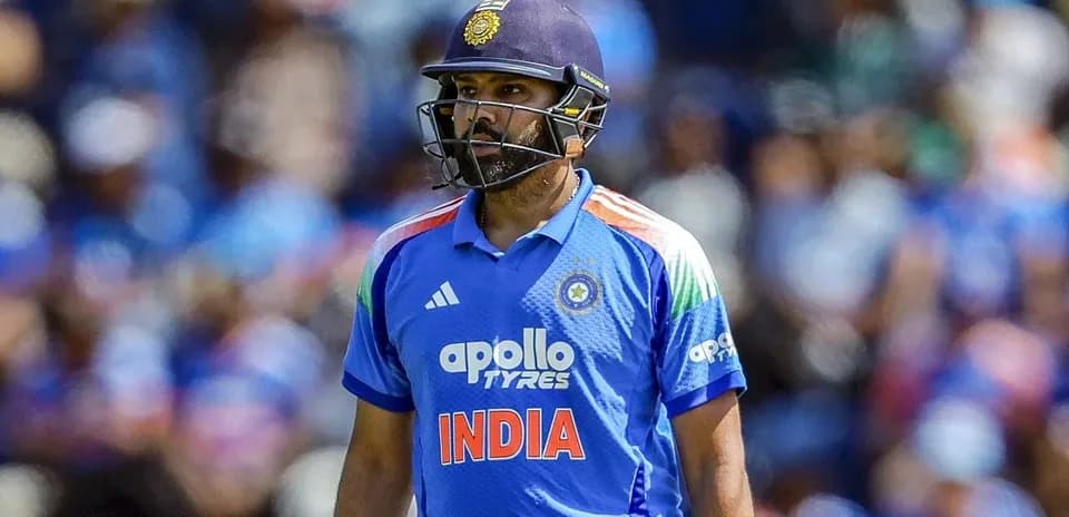 Cricketer in blue uniform walking on the field