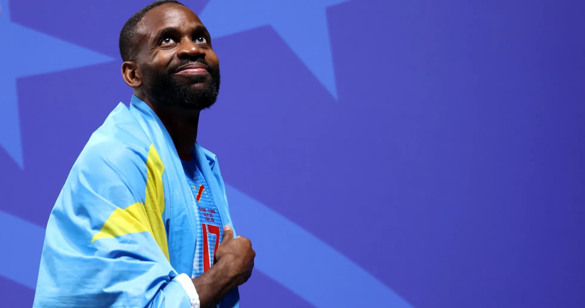 Athlete wearing a blue flag, looking upwards