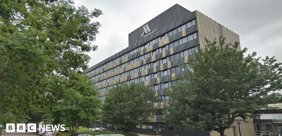 Marriott hotel building with trees and parked cars