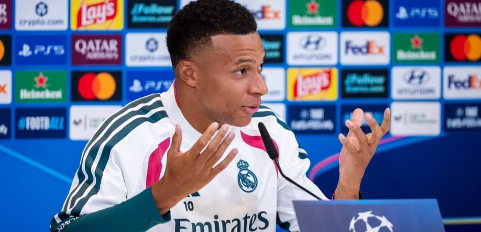 Player speaking at press conference with logos backdrop
