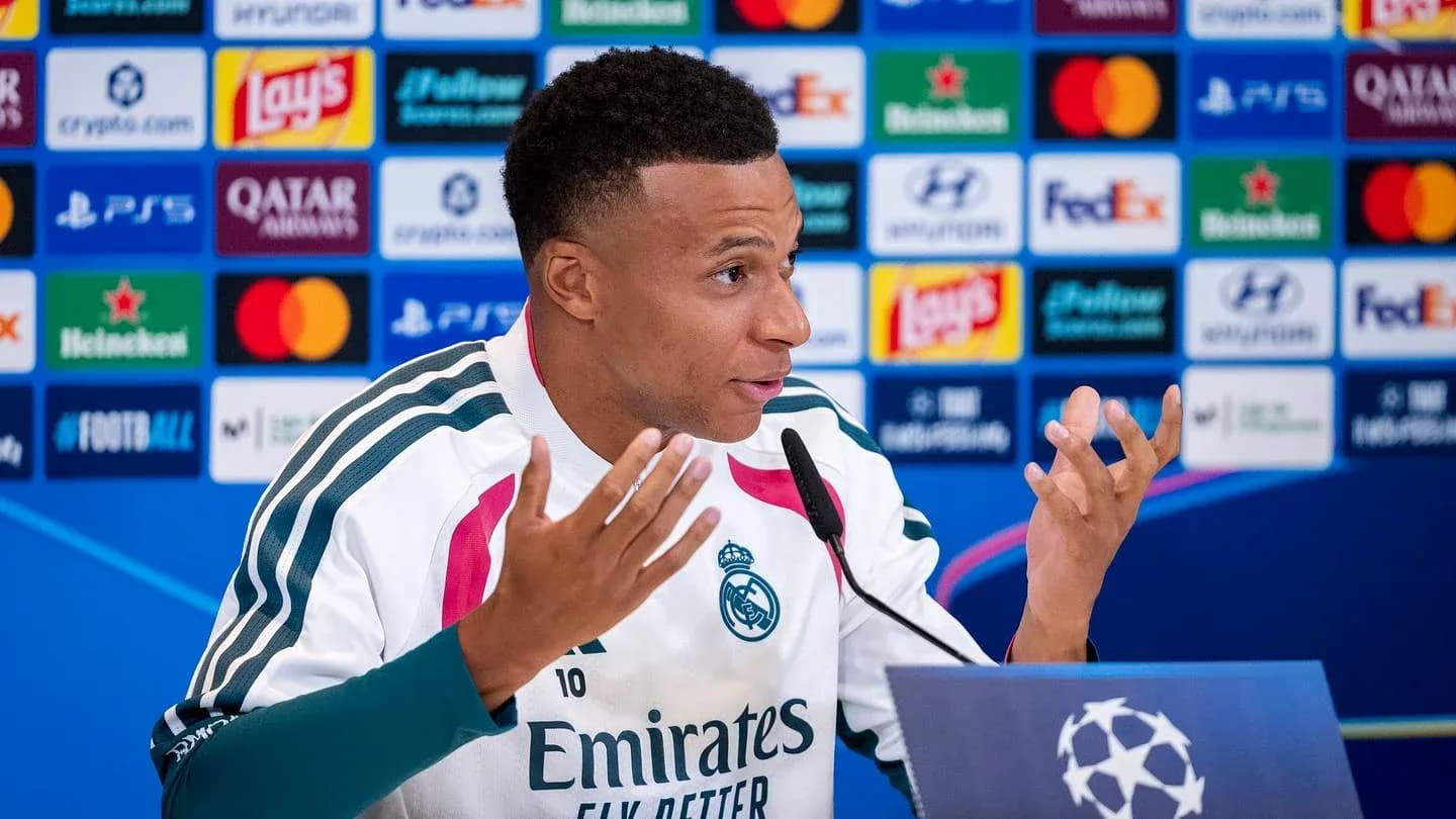 Player speaking at press conference with logos backdrop