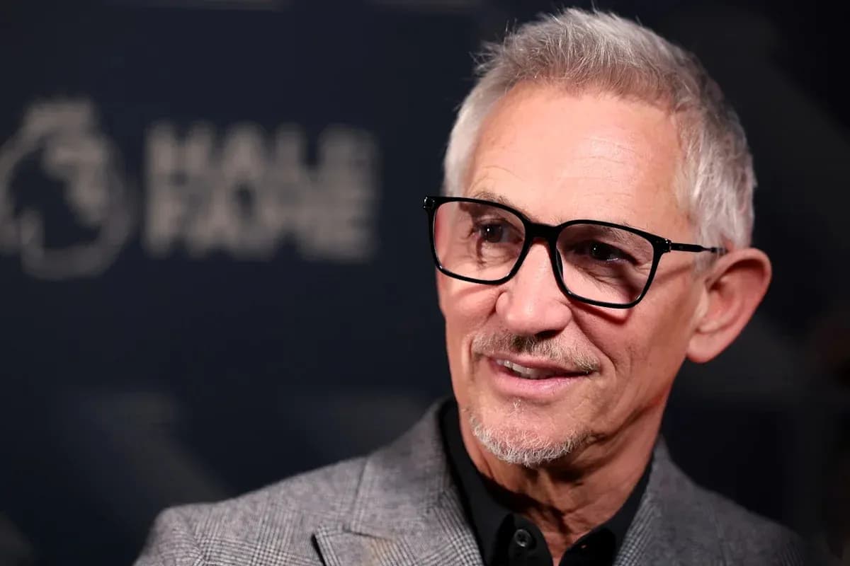 Man with glasses at a press event backdrop