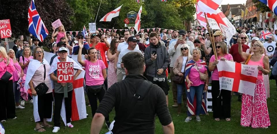 Crowd protesting with banners and flags in park