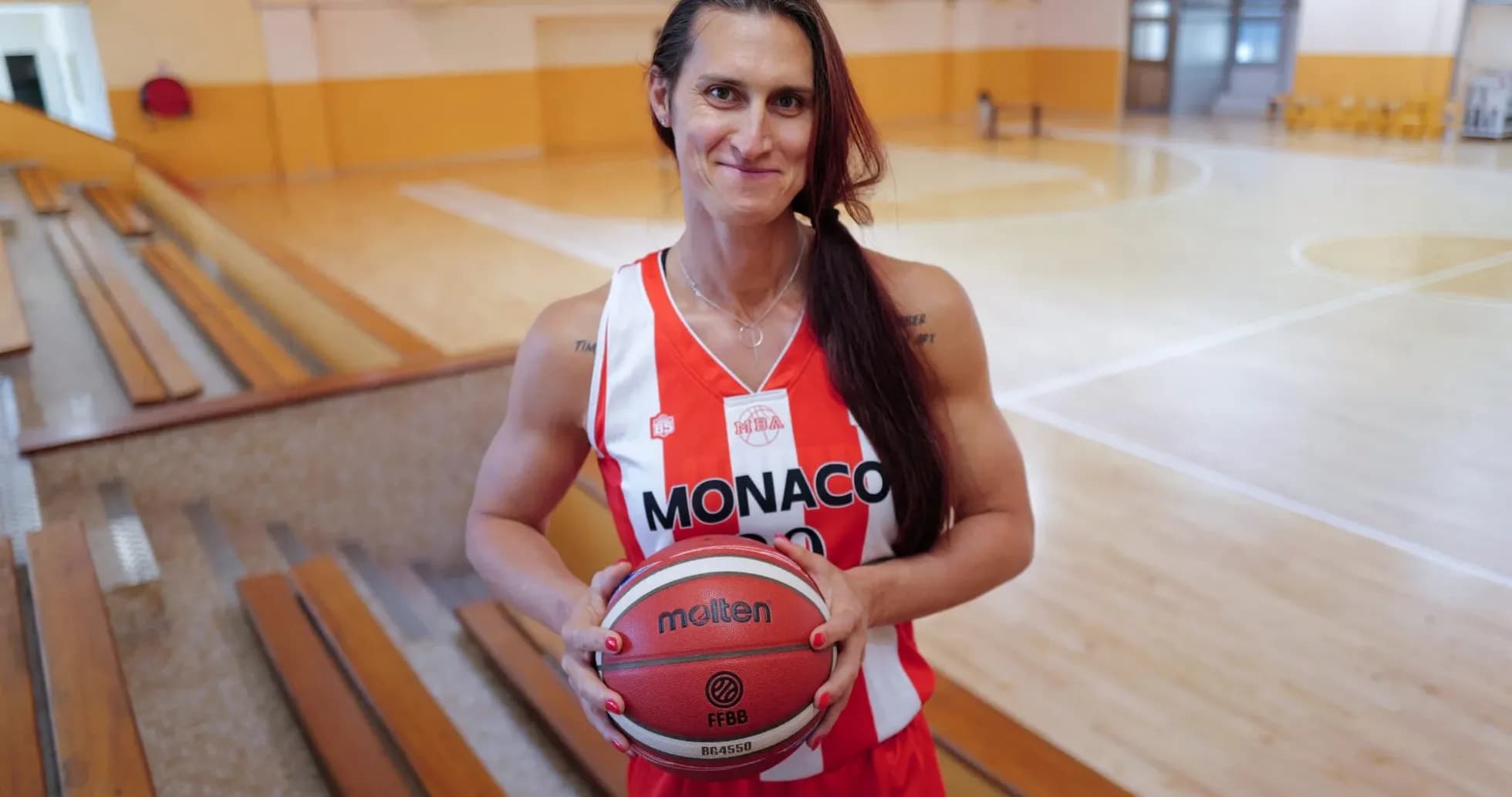 Basketball player holding a ball in gym