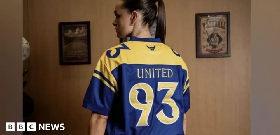 Person wearing a blue and yellow jersey with '93' and 'UNITED'