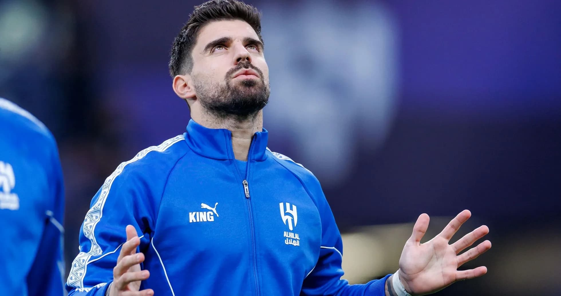 Player in blue tracksuit looking upwards during warm-up Player in blue tracksuit looking upwards during warm-up
