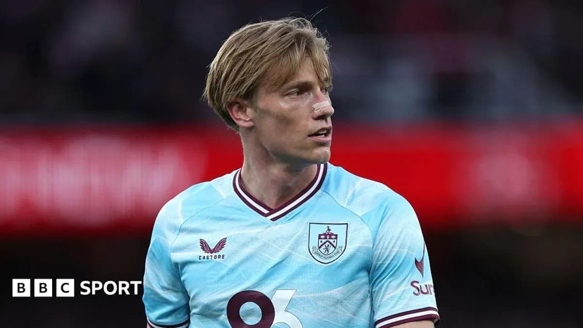 Player in light blue Burnley jersey on field Player in light blue Burnley jersey on field