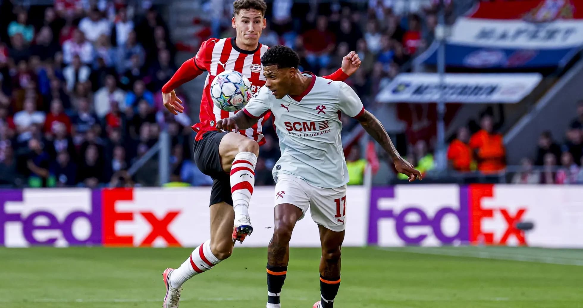 Two players contesting for the ball on the field Two players contesting for the ball on the field