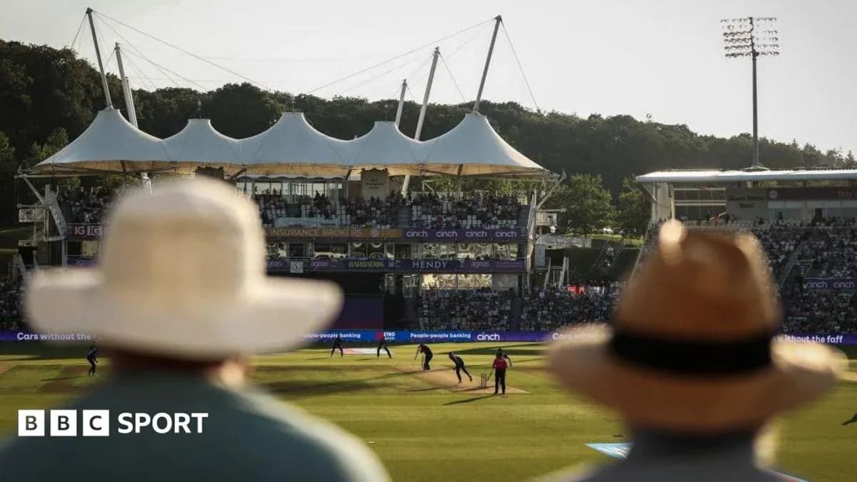 Cricket match in progress with spectators in foreground Cricket match in progress with spectators in foreground