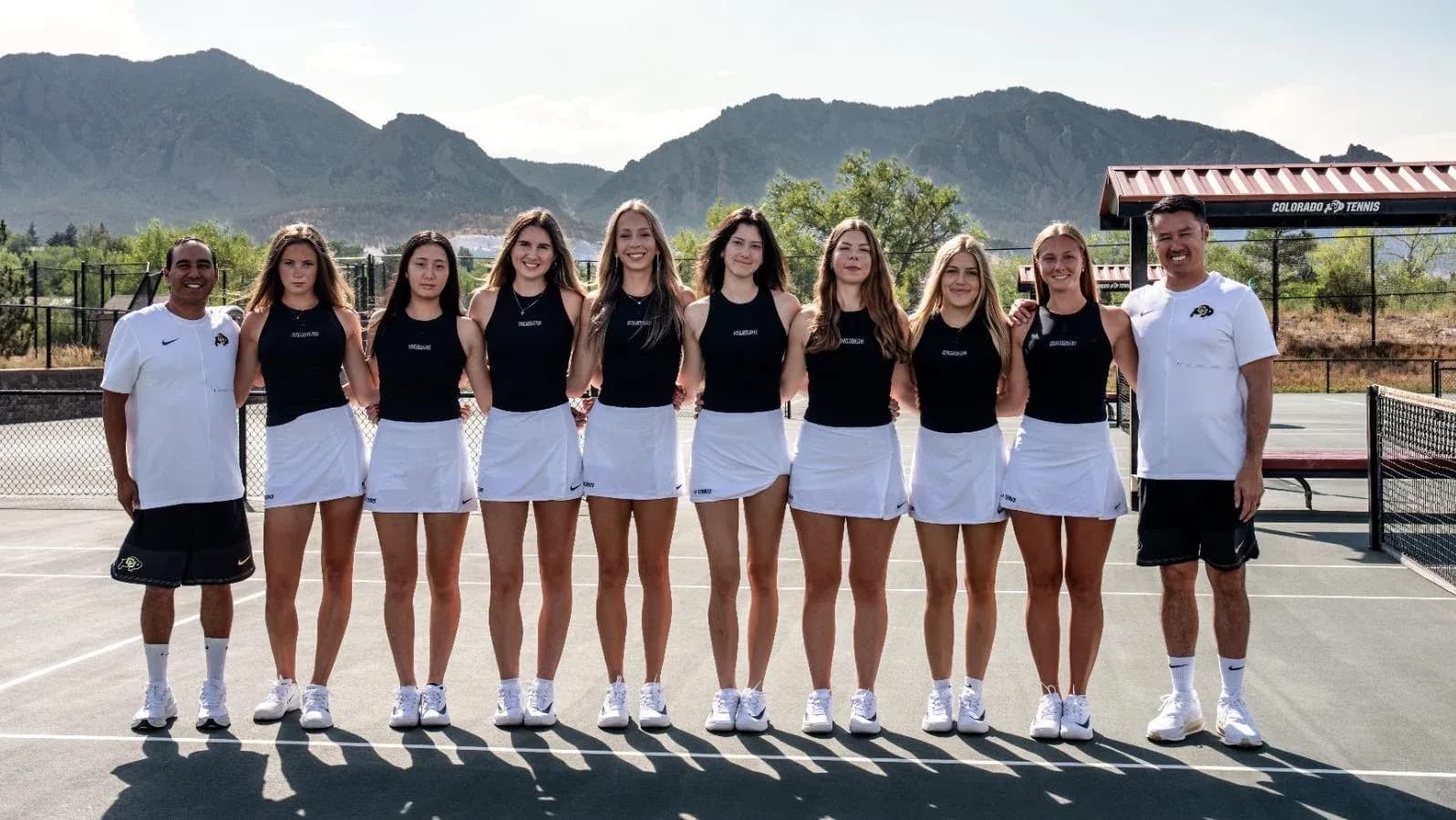 Tennis team posing together on outdoor court Tennis team posing together on outdoor court