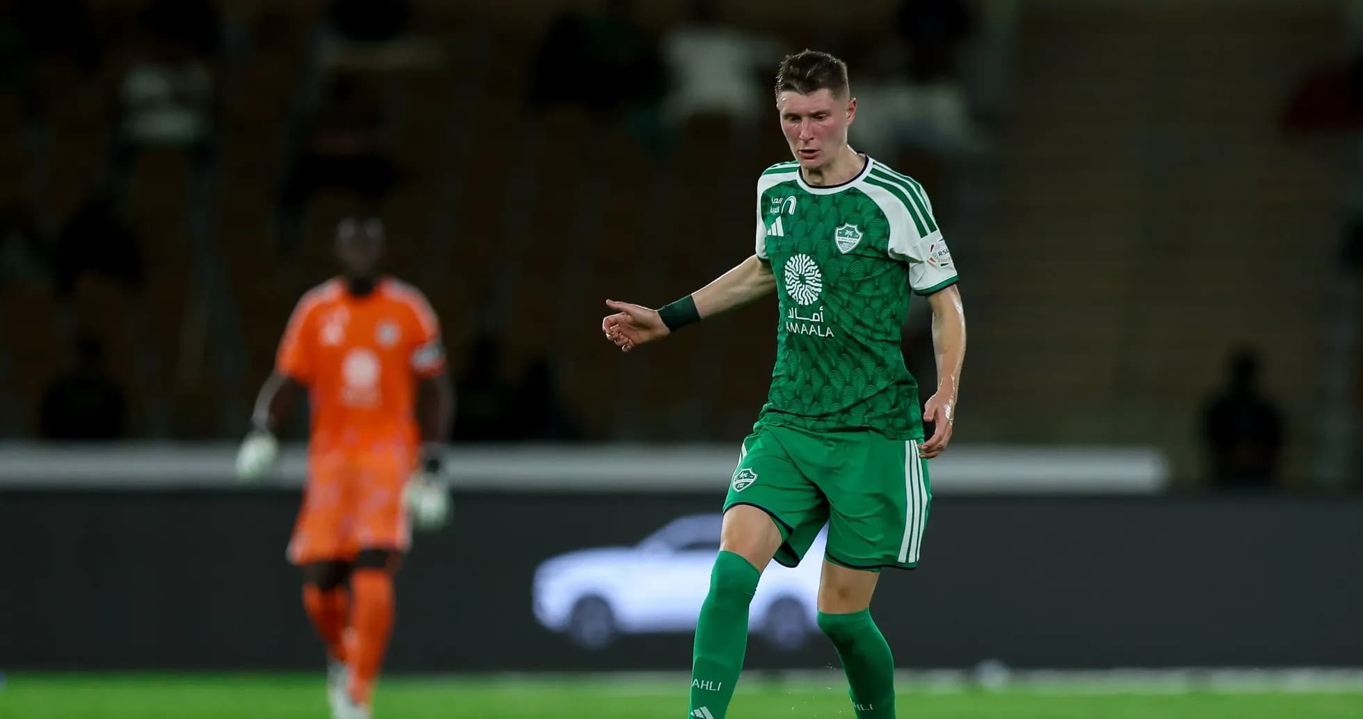 Player in green uniform dribbling the ball Player in green uniform dribbling the ball