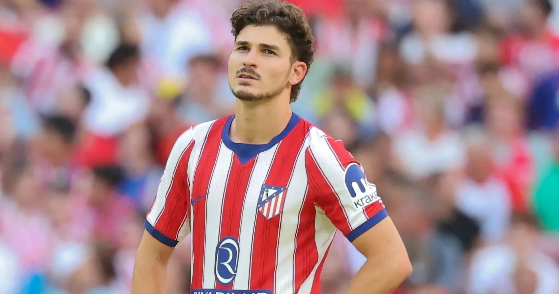 Atletico Madrid player during match with fans in background Atletico Madrid player during match with fans in background