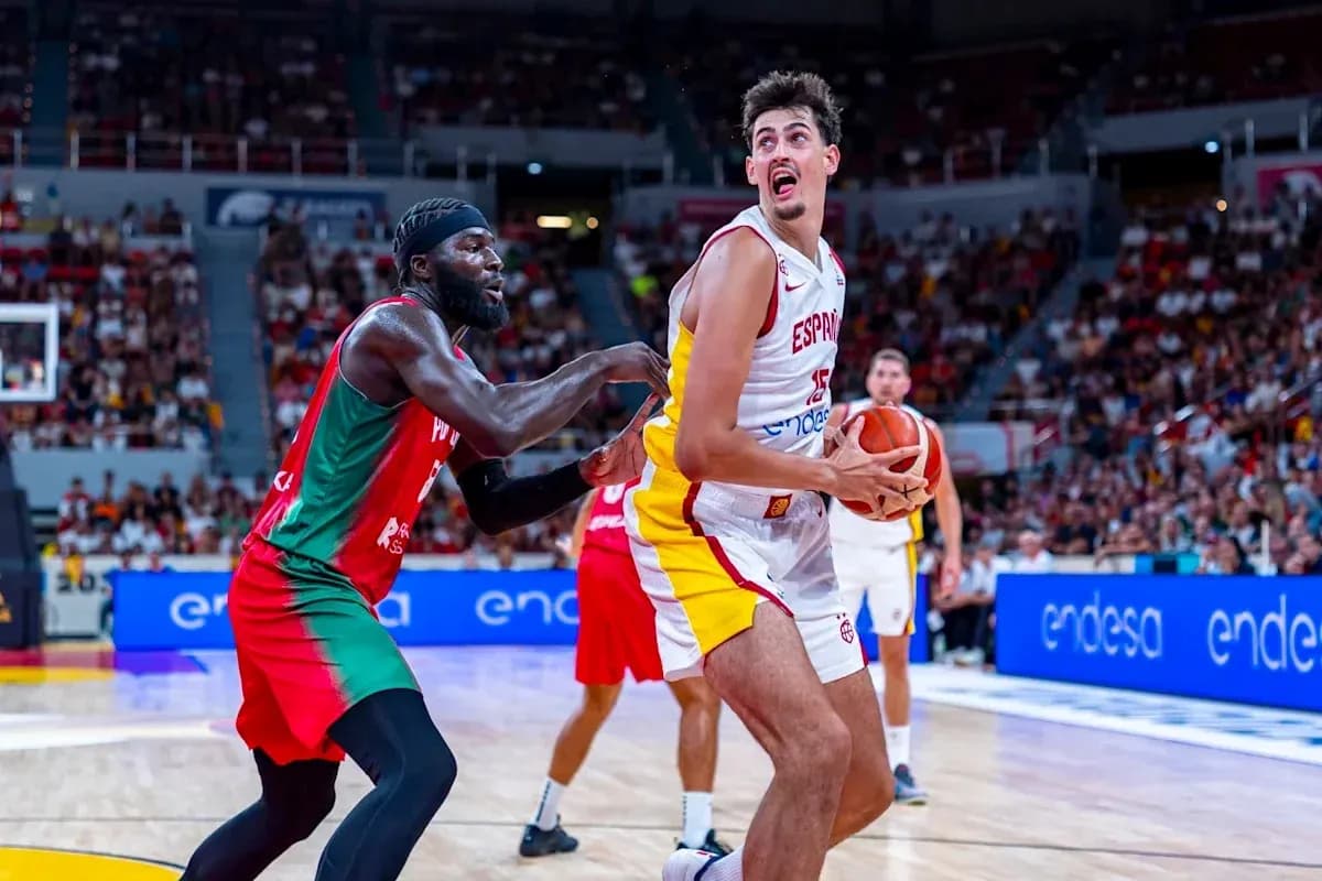 Player from Spain holding the basketball, defender reaching Player from Spain holding the basketball, defender reaching