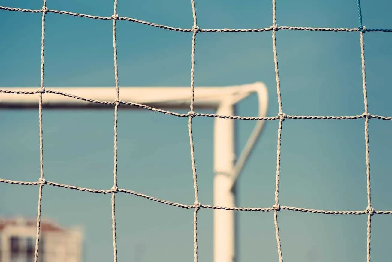 Close-up of a soccer goal net with blue sky Close-up of a soccer goal net with blue sky