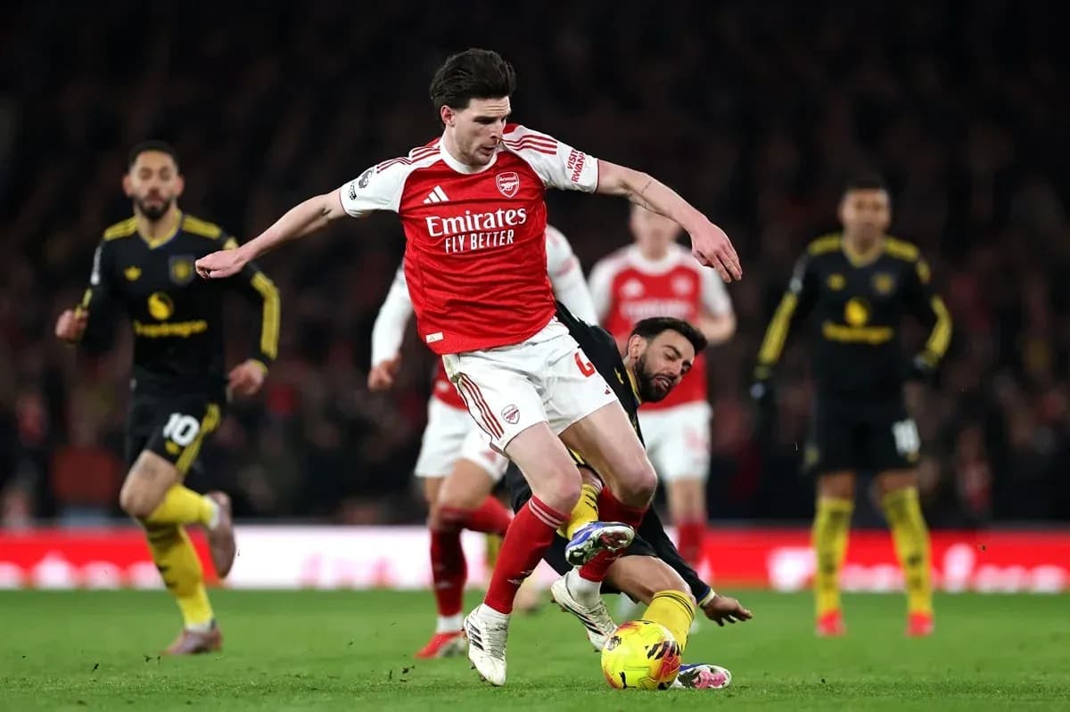 Player from Arsenal evading a tackle during match Player from Arsenal evading a tackle during match