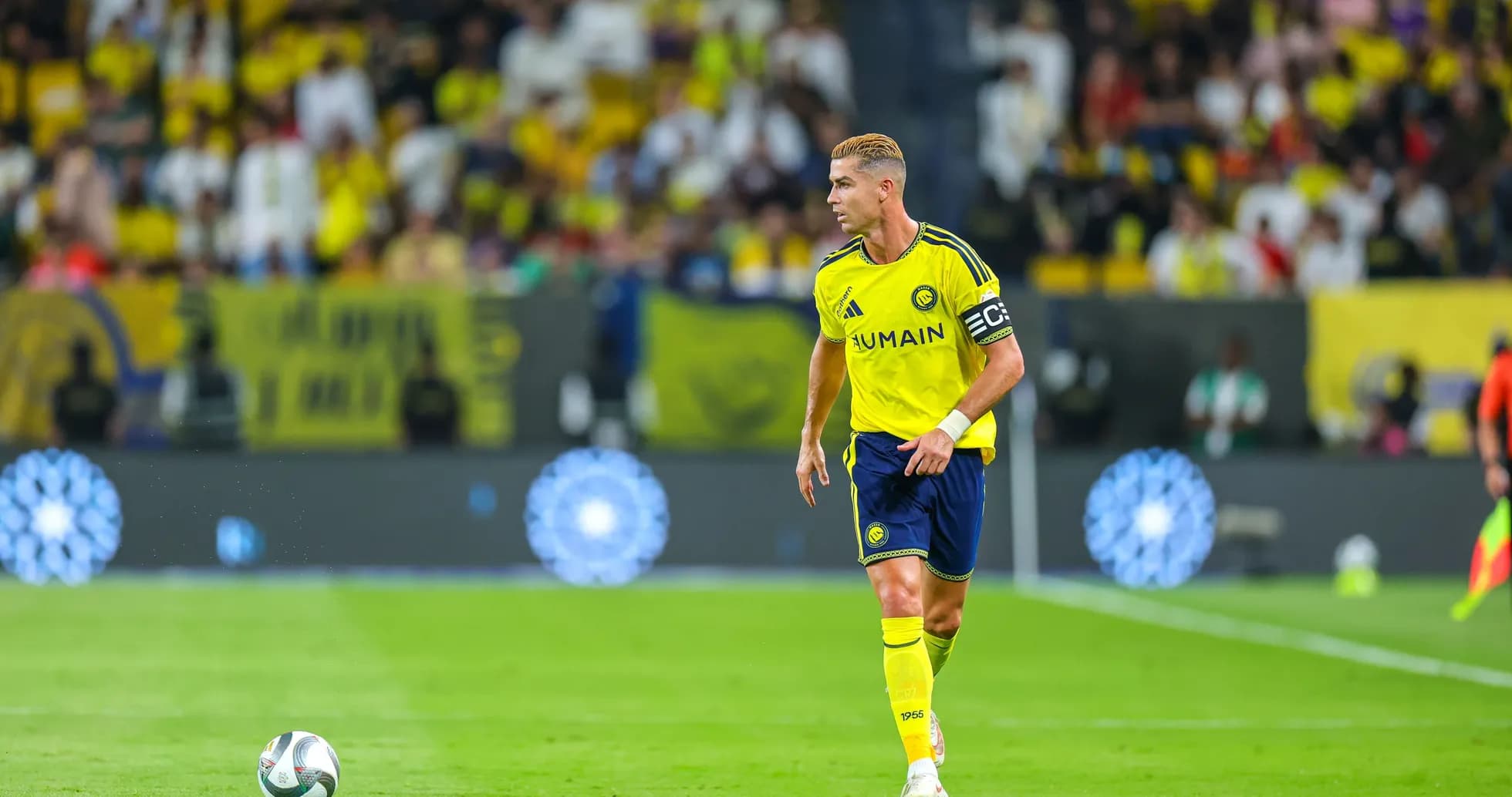 Player in yellow kit with captain's armband on field Player in yellow kit with captain's armband on field