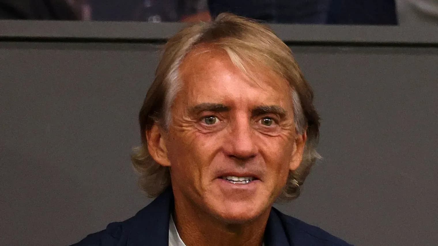 Coach smiling in a sports venue setting Coach smiling in a sports venue setting