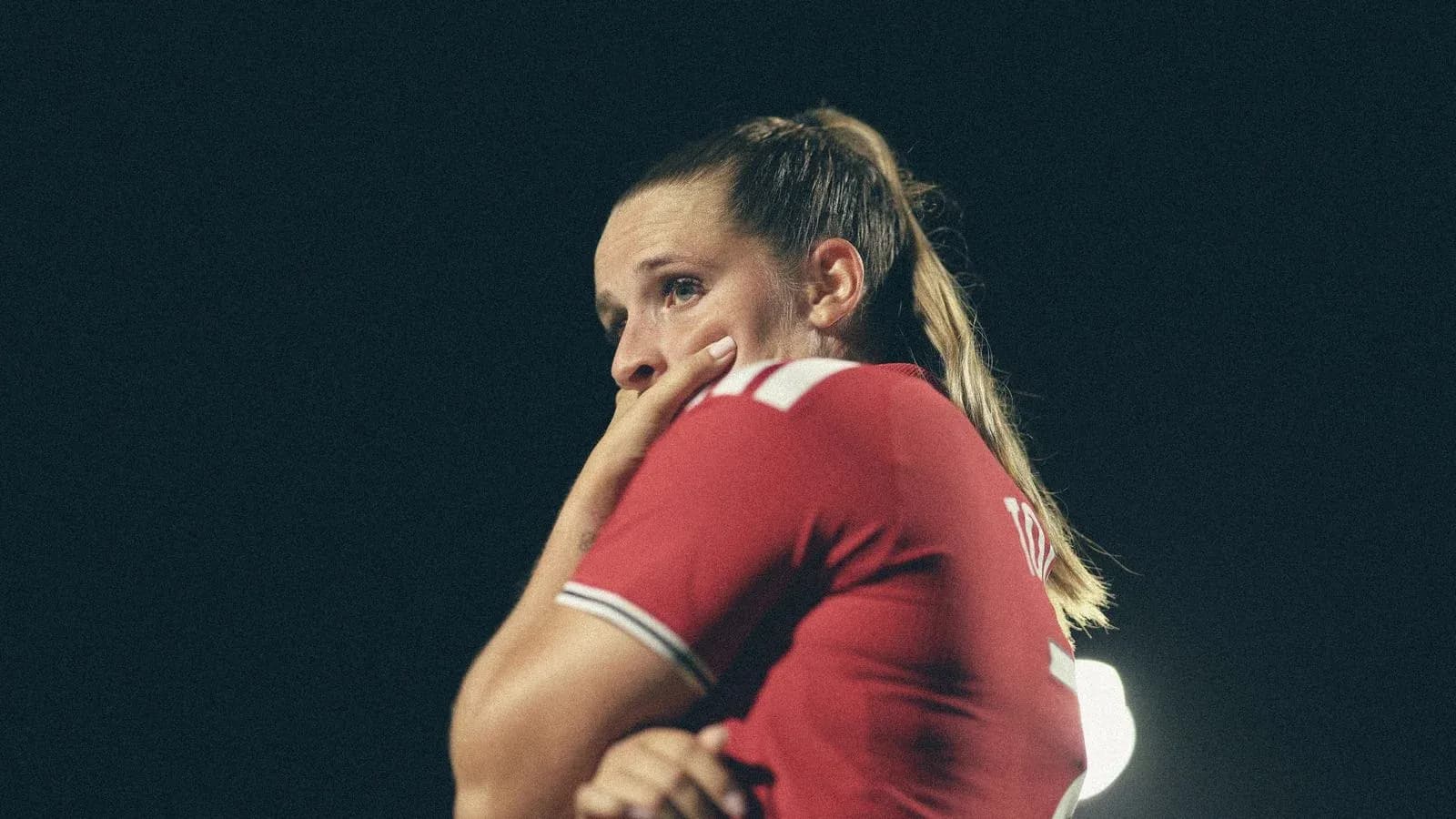 Player in red jersey with hand on face Player in red jersey with hand on face
