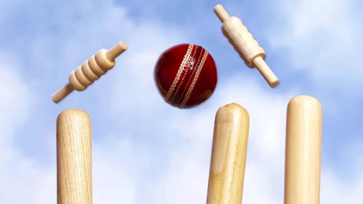 Cricket ball hitting stumps with bails flying Cricket ball hitting stumps with bails flying