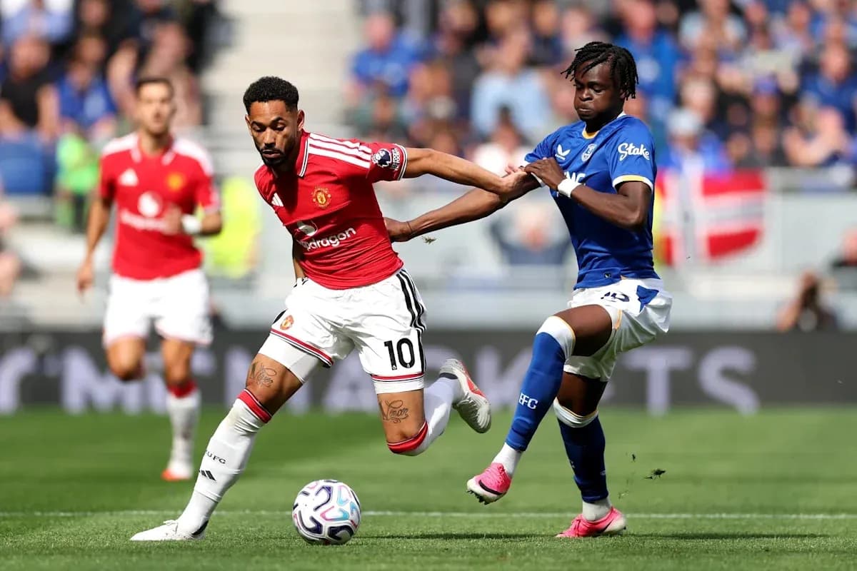 Player from Manchester United evading tackle from Everton player Player from Manchester United evading tackle from Everton player