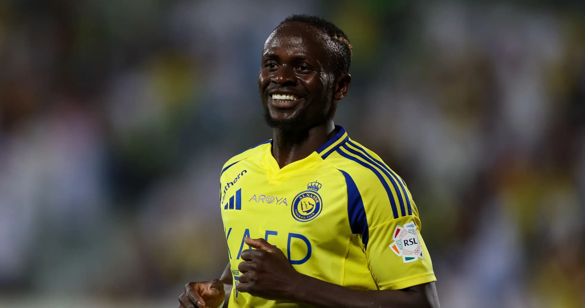 Player in yellow jersey smiling on the field Player in yellow jersey smiling on the field