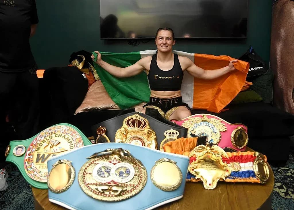 Boxer holding Irish flag with championship belts displayed Boxer holding Irish flag with championship belts displayed
