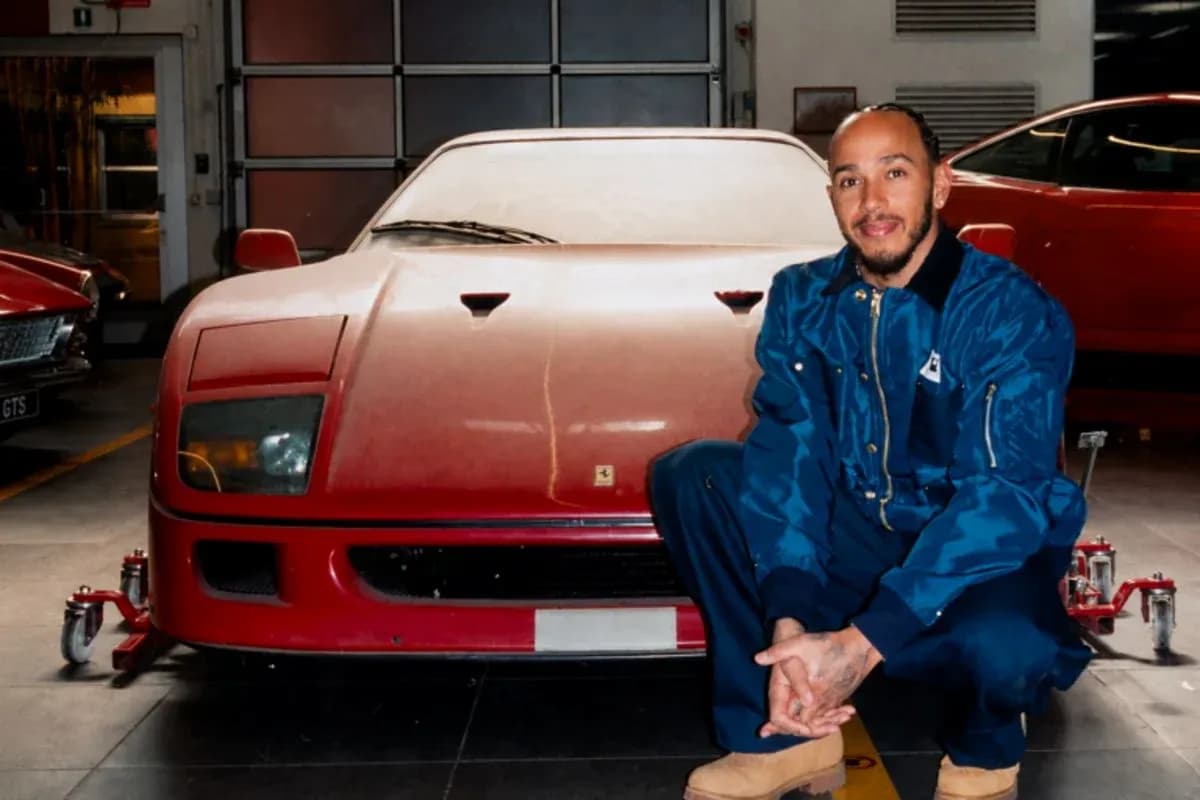 Man kneeling beside a vintage red Ferrari in garage Man kneeling beside a vintage red Ferrari in garage