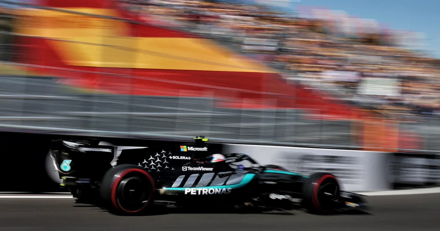 Formula 1 car speeding past grandstand at race Formula 1 car speeding past grandstand at race