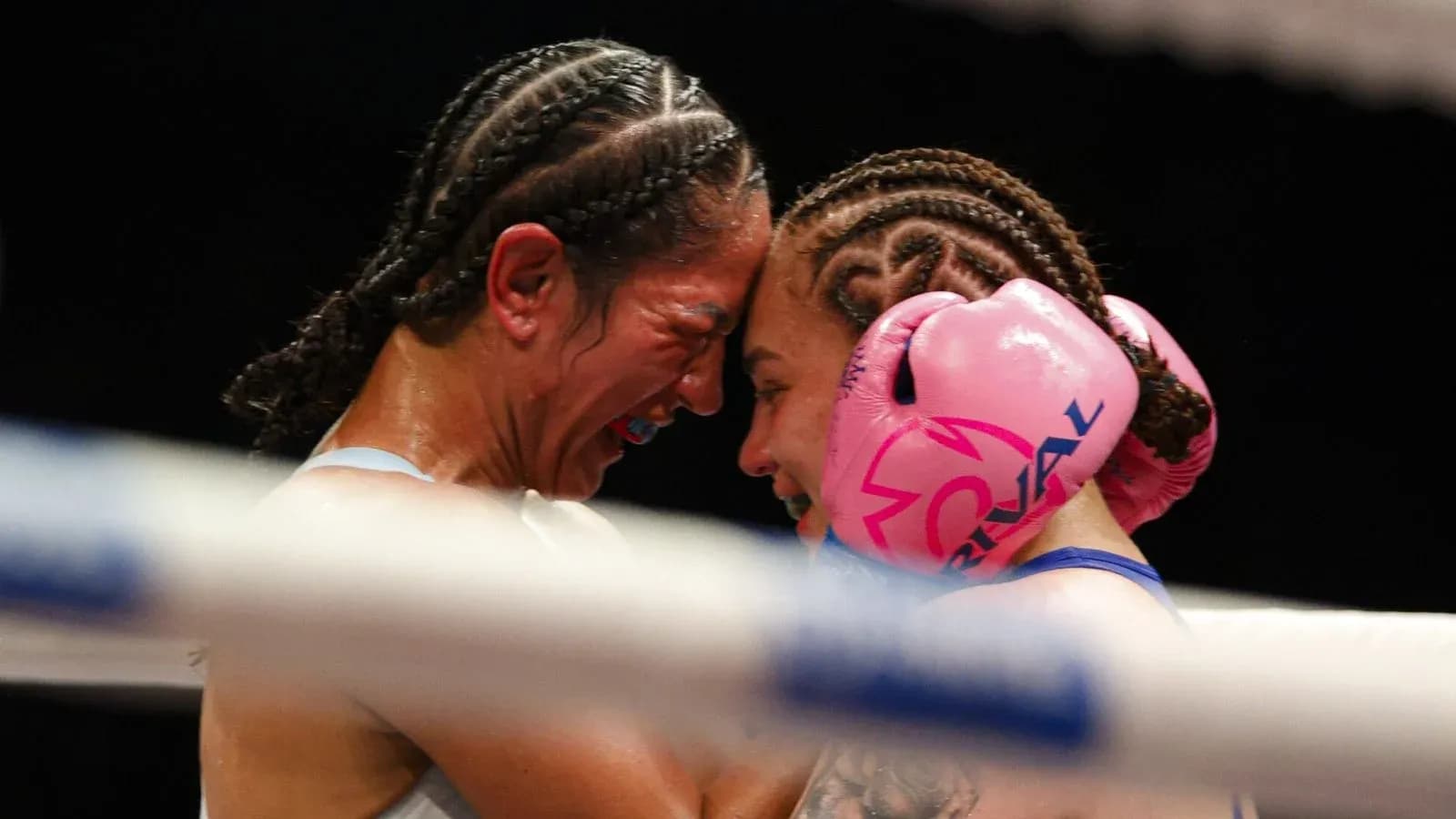 Two female boxers in close embrace during match Two female boxers in close embrace during match