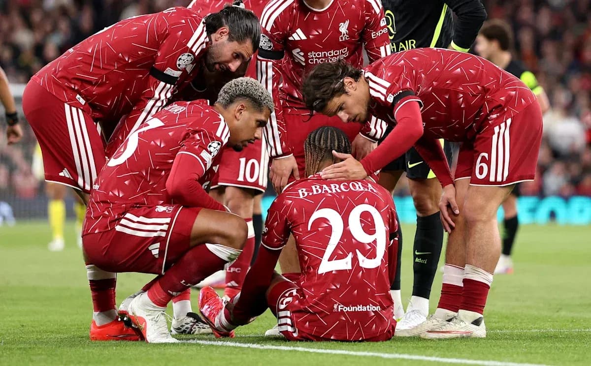 Liverpool players comforting injured teammate on pitch Liverpool players comforting injured teammate on pitch